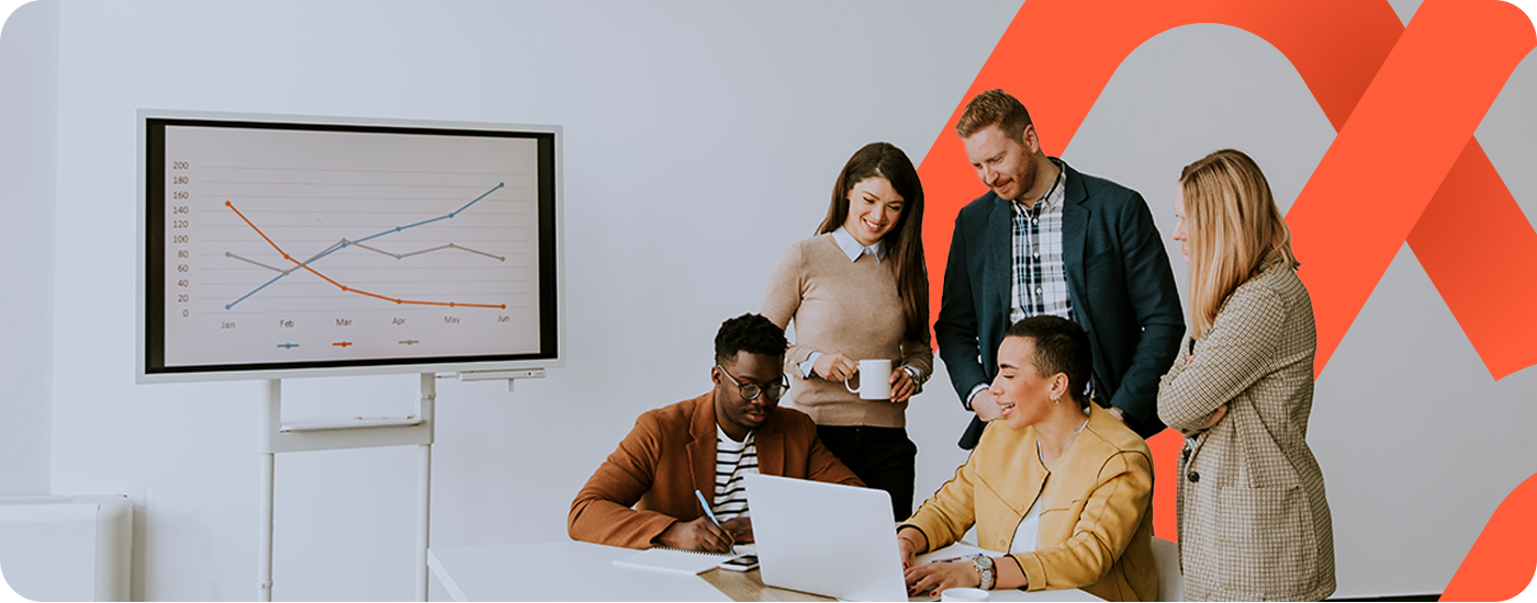 Grupo de pessoas reunidas atrás de um computador observando gráficos e fazendo análises